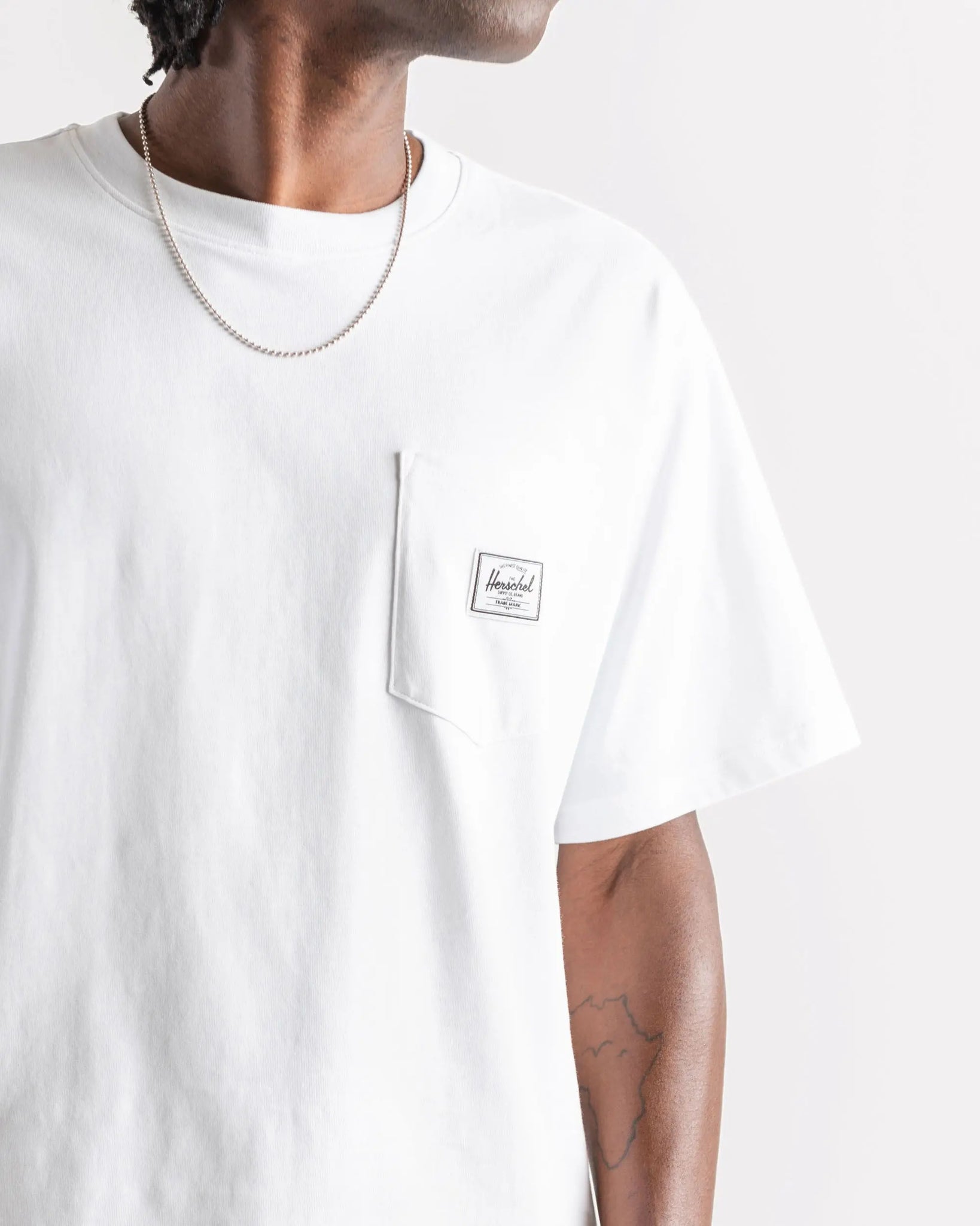 Weißes T-Shirt mit HERSCHEL-Tasche